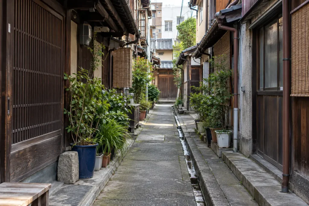 古い住宅が建ち並ぶ細い私道と側溝
