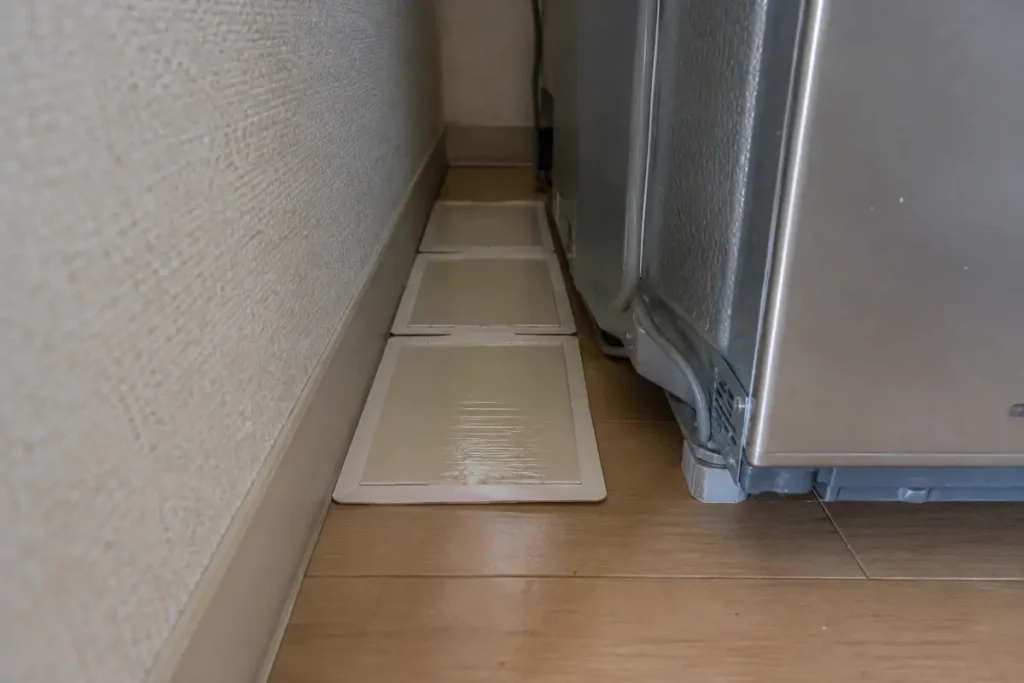 冷蔵庫の裏の壁ぎわに並べた粘着シート